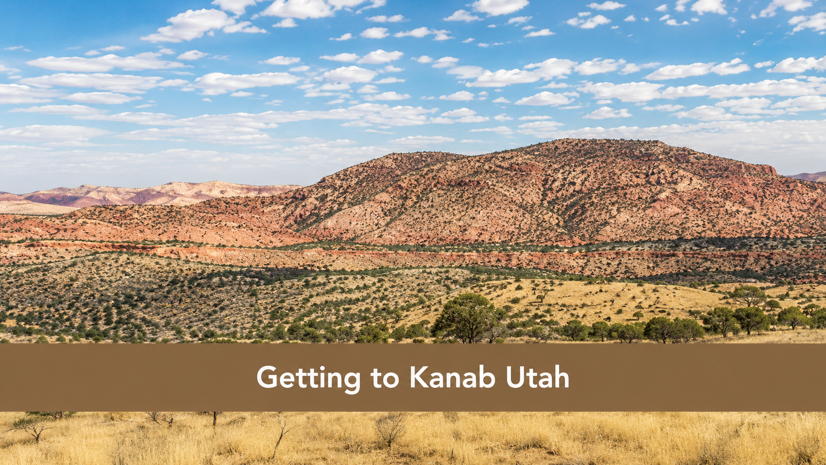 A scenic desert landscape with layered red and tan hills under a blue sky with scattered clouds. Text across the image reads: “Getting to Kanab Utah.”.