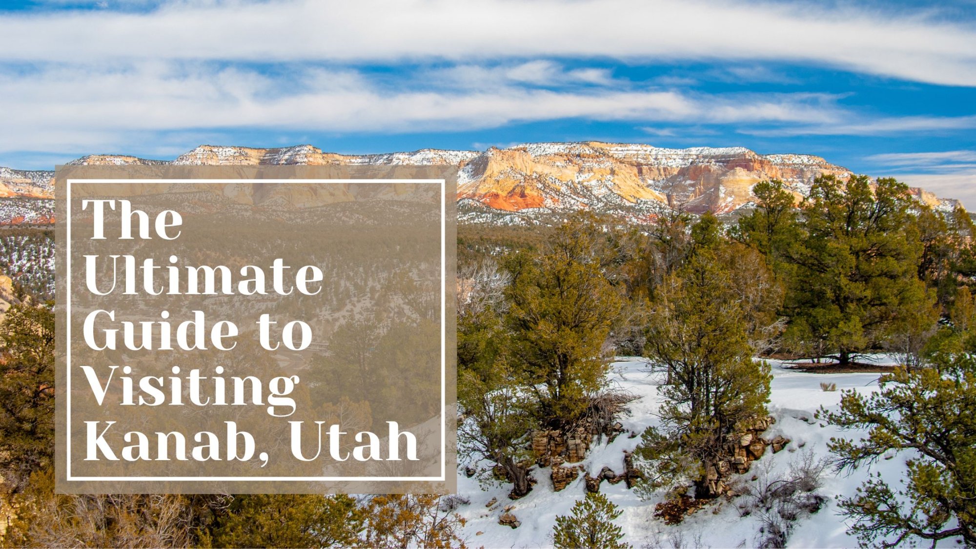 Snowy landscape with green trees and red rock cliffs under a blue sky. Text overlay reads: “The Ultimate Guide to Visiting Kanab, Utah.”.
